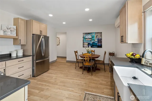 a living room with stainless steel appliances furniture and a kitchen view