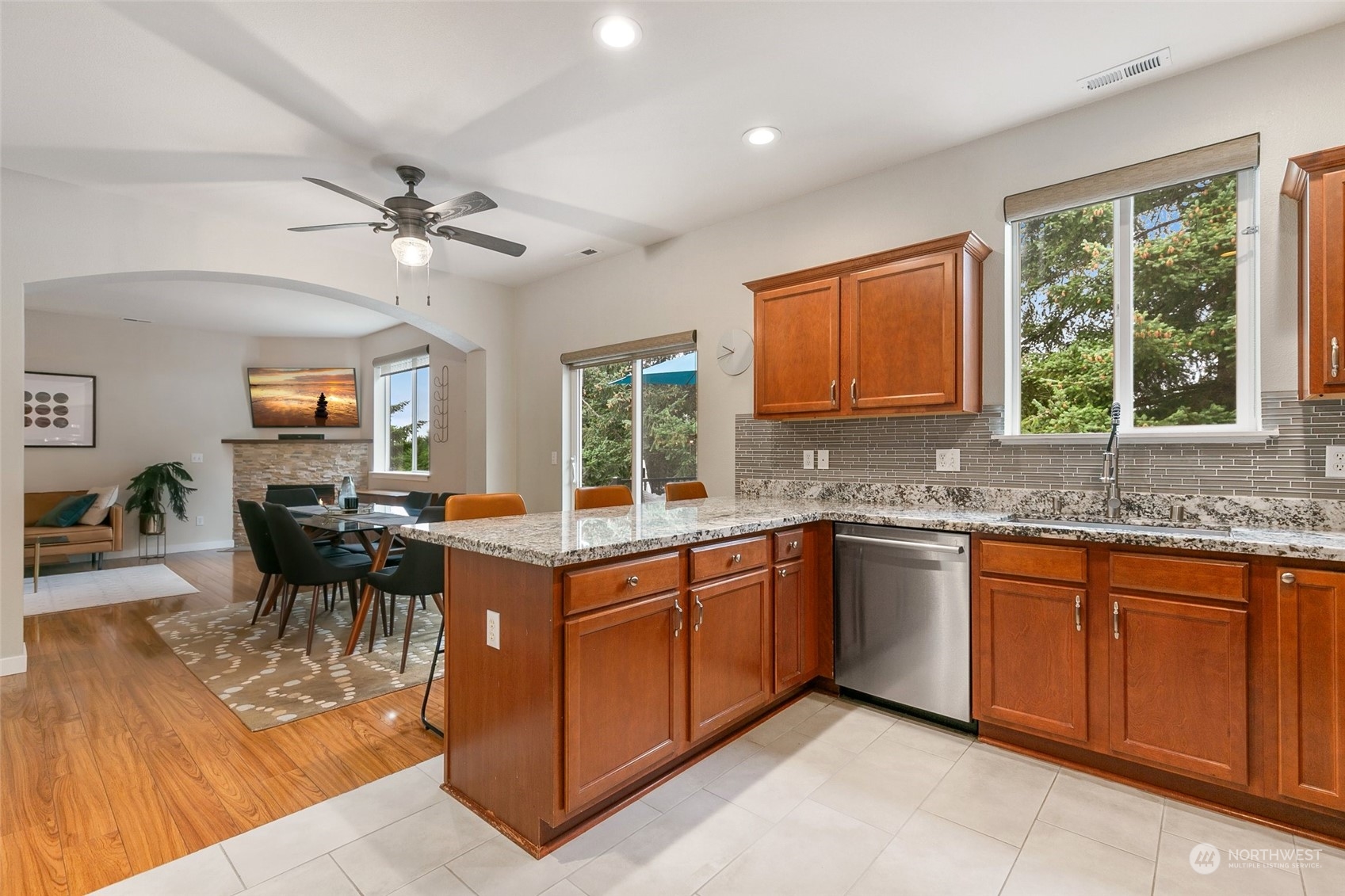 573 Field Place Northeast Renton, WA 98059 - Photo 12 of 34 a open kitchen with stainless steel appliances granite countertop a stove top oven a sink dishwasher a dining table and chairs with wooden floor