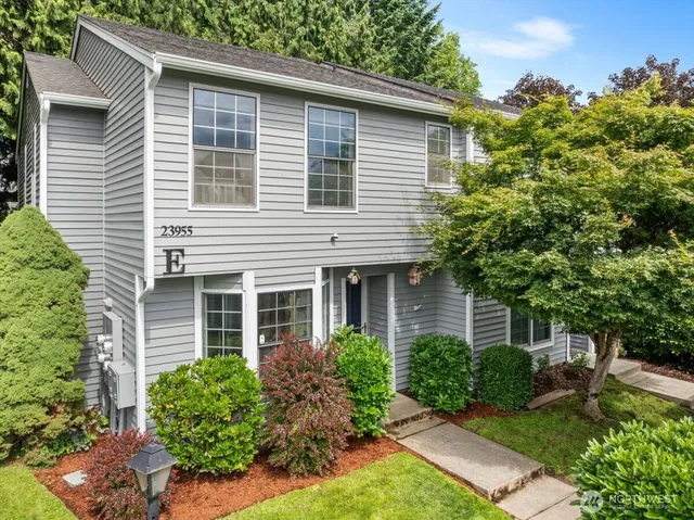 a view of a house with a yard and potted plants