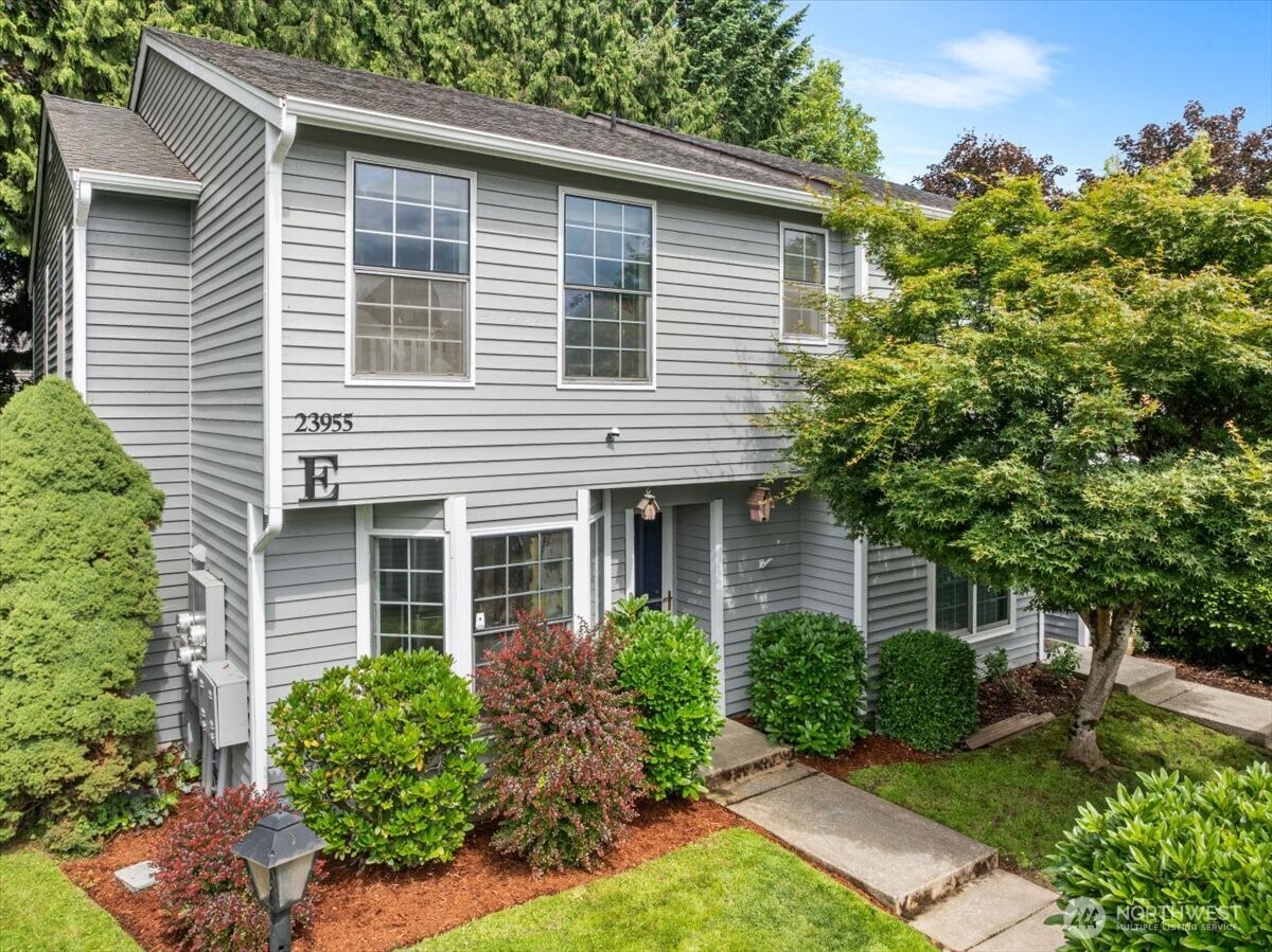 a view of a house with a yard and potted plants