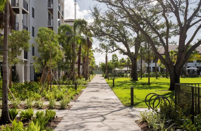 a view of a park with plants and large trees