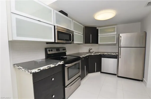 a kitchen with stainless steel appliances granite countertop a stove a refrigerator and a microwave