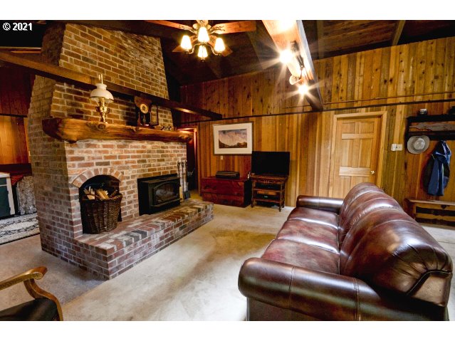 28730 Road 20 Rhododendron, OR 97049 - Photo 5 of 28 a living room with furniture a fireplace and a flat screen tv