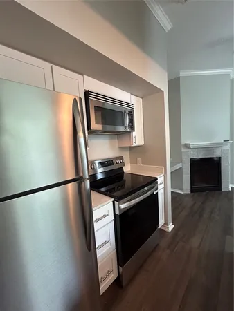 a kitchen with granite countertop a refrigerator stove and microwave