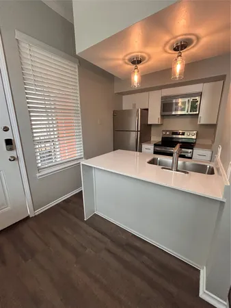 a room with stainless steel appliances wooden floors and view living room