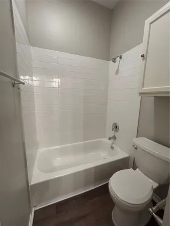 an empty room with wooden floor cabinet and windows
