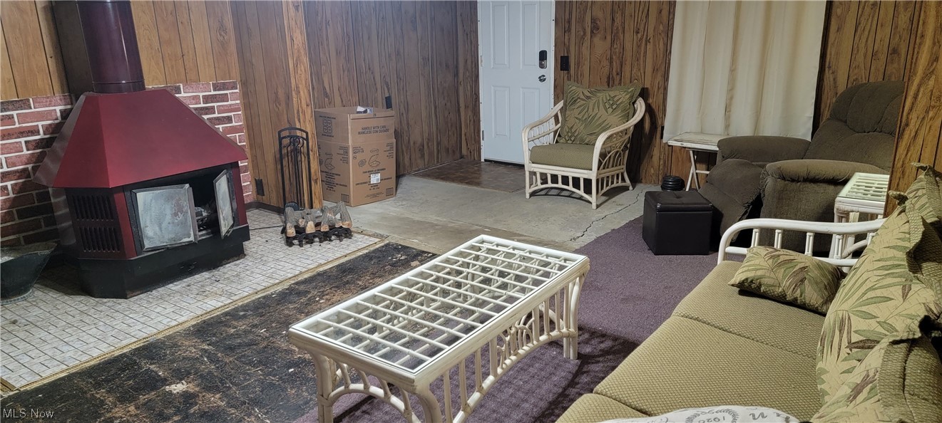 1441 State Road Northwest Warren, OH 44481 - Photo 18 of 19 2nd sunken Family room with wooden walls, a wood stove, and dark tile flooring