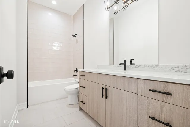 a bathroom with a double vanity sink toilet mirror and bathtub