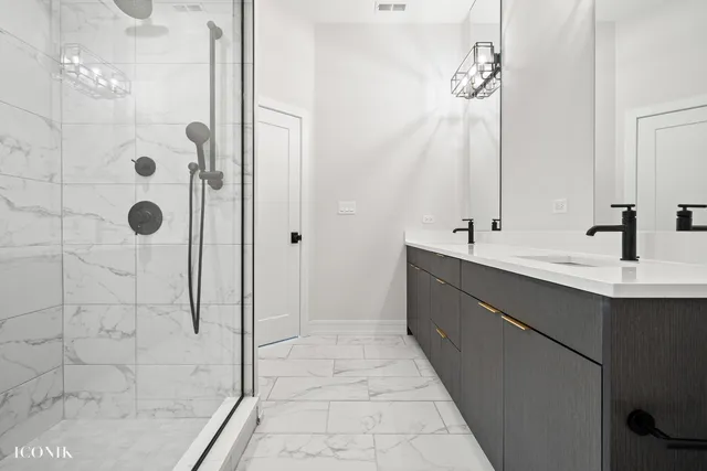 a bathroom with a double vanity sink mirror and shower