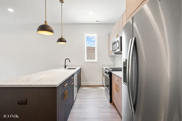 a kitchen with stainless steel appliances granite countertop a refrigerator a sink and a stove