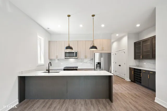 a large kitchen with a sink and dishwasher a stove top oven with wooden floor