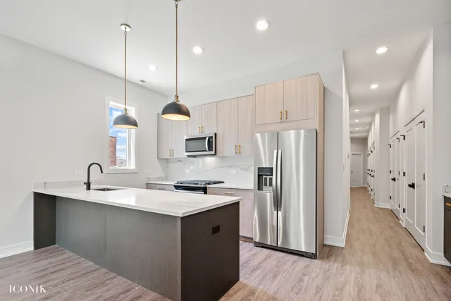 a kitchen with refrigerator cabinets and wooden floor