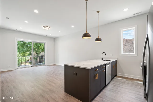a kitchen with stainless steel appliances granite countertop a sink a window and wooden floor
