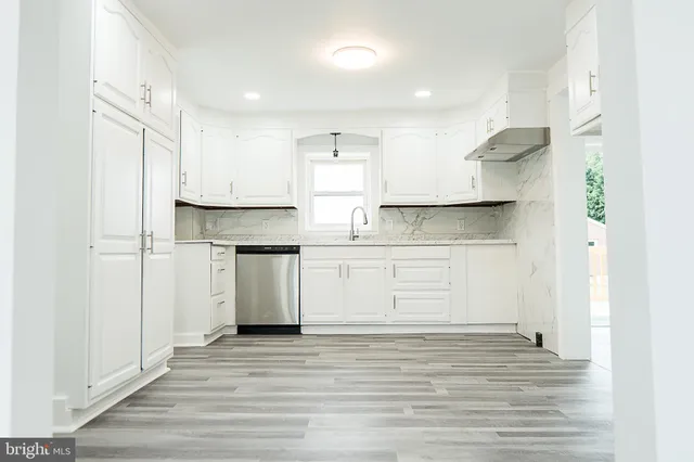 a kitchen with kitchen island white cabinets and stainless steel appliances