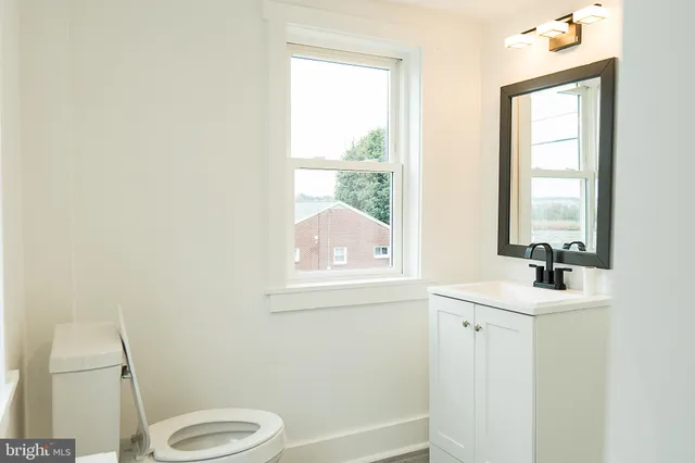 a bathroom with a sink a toilet and a window