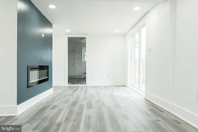 an empty room with wooden floor and mirror