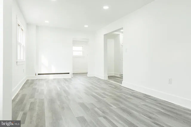 a view of an empty room with wooden floor