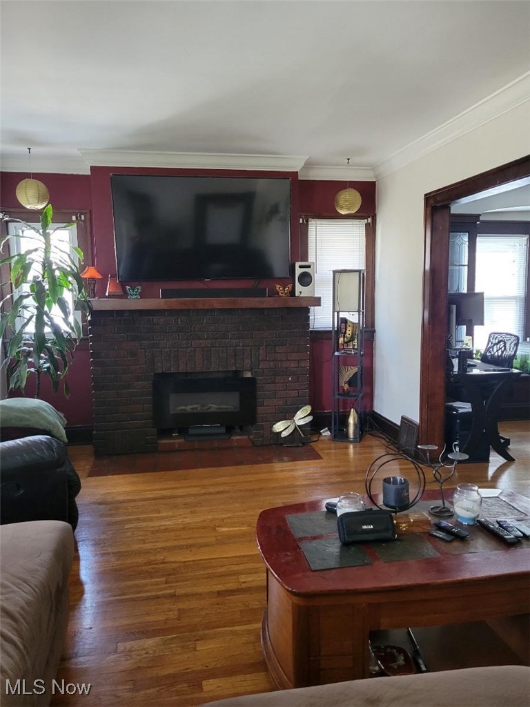 3276 Berea Road Cleveland, OH 44111 - Photo 10 of 10 Living room with a brick fireplace, wood-type flooring, ornamental molding, and a wealth of natural light