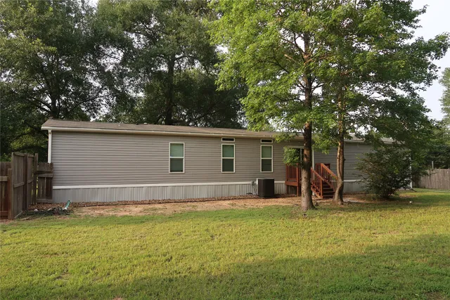 a view of a house with backyard and tree