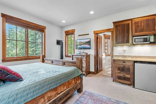 a bedroom with a bed dresser and a large window