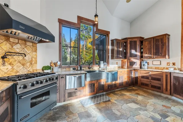 a kitchen with stainless steel appliances granite countertop a stove a sink and a microwave