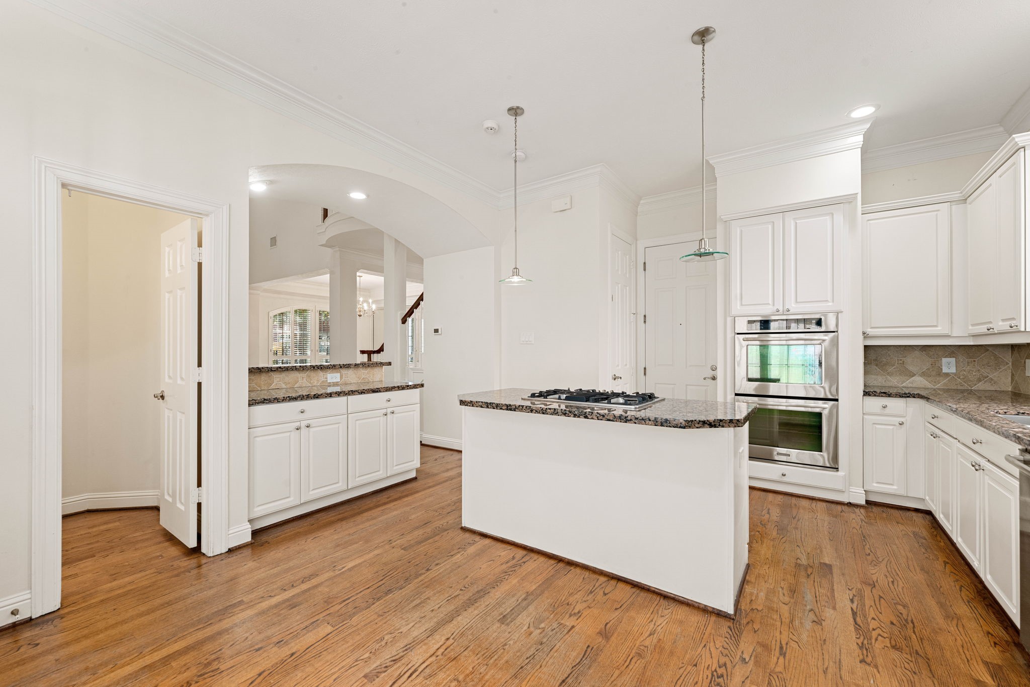 5318 Fayette Street Houston, TX 77056 - Photo 10 of 35 a large kitchen with granite countertop a stove top oven a sink a refrigerator and white cabinets with wooden floor