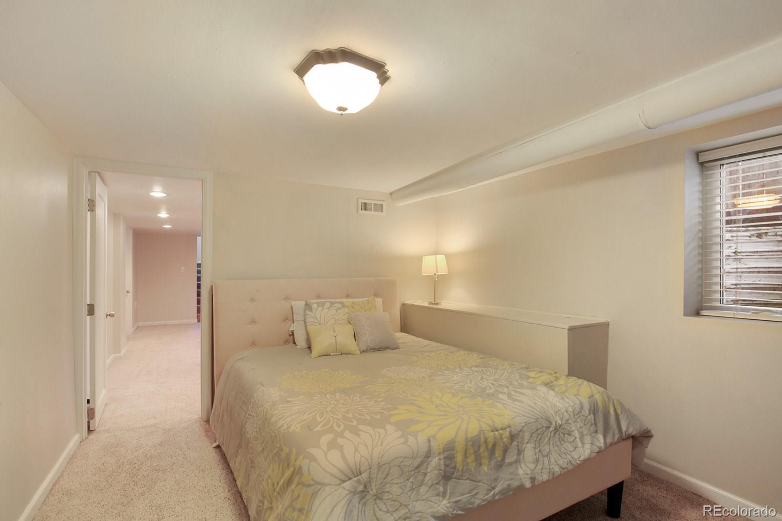 3877 Perry Street Denver, CO 80212 - Photo 18 of 23 a bedroom with a bed and a chandelier