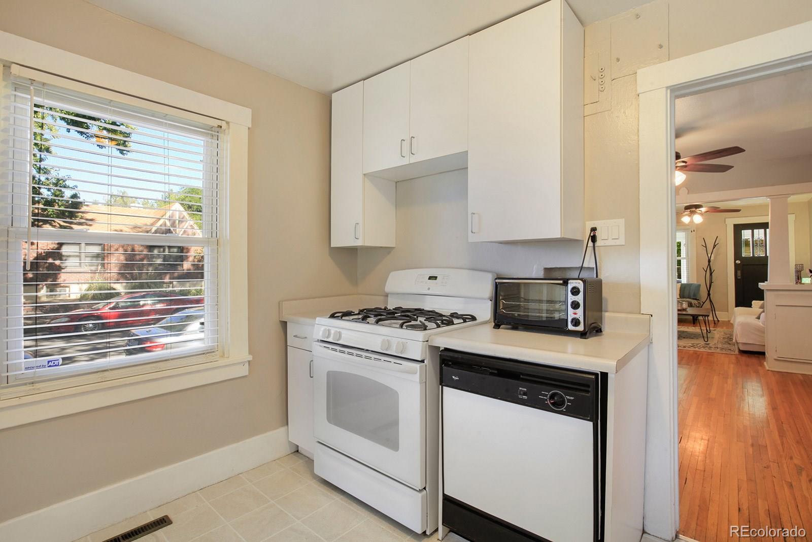 3877 Perry Street Denver, CO 80212 - Photo 9 of 23 a kitchen with white cabinets and appliances