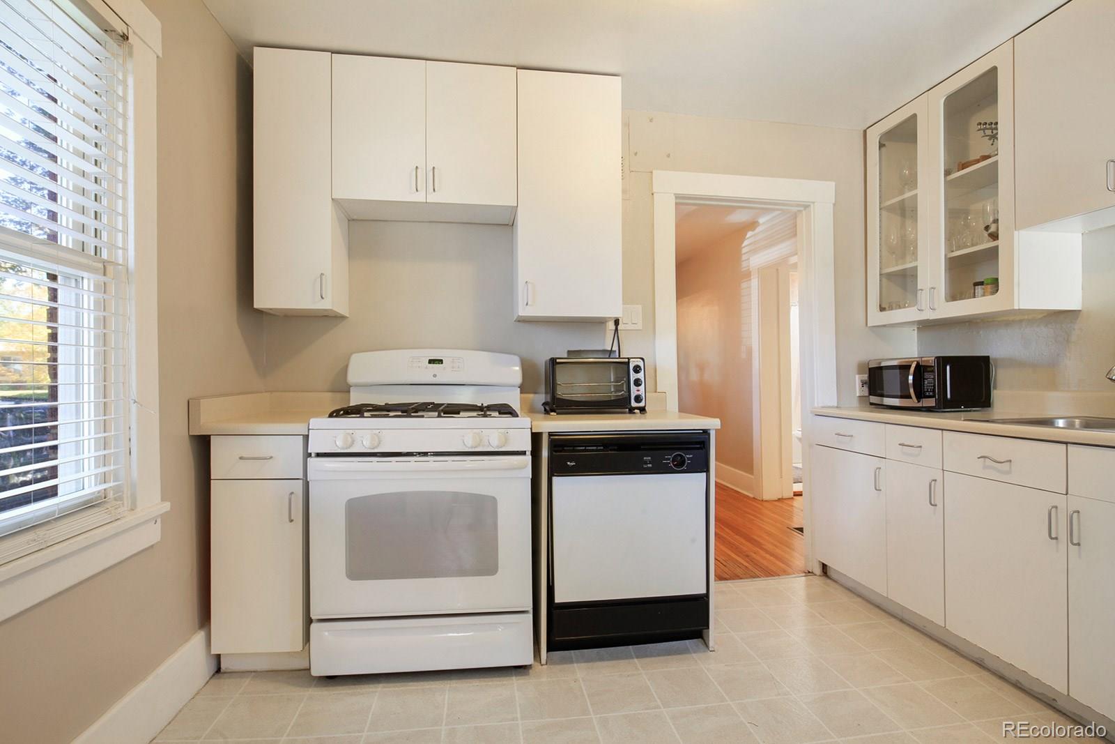 3877 Perry Street Denver, CO 80212 - Photo 10 of 23 a kitchen with white cabinets and white appliances