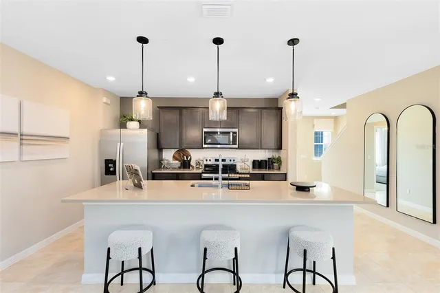 a kitchen with stainless steel appliances granite countertop a kitchen island a stove and a cabinets