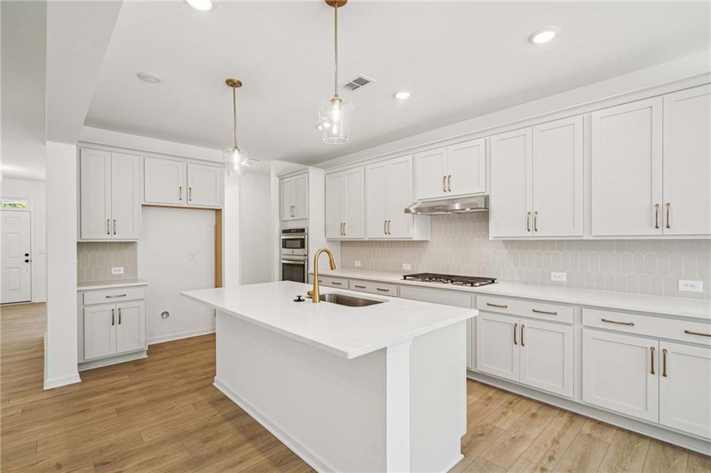 240 Silverleaf Trail Bethlehem, GA 30620 - Photo 7 of 39 a kitchen with stainless steel appliances granite countertop a white stove top oven and white cabinets
