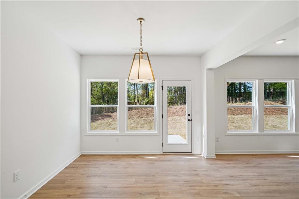 240 Silverleaf Trail Bethlehem, GA 30620 - Photo 10 of 39 a view of an empty room with wooden floor and a window