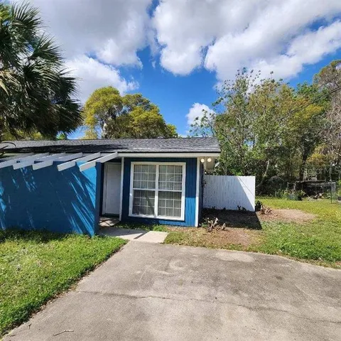 a front view of a house with a garden and trees