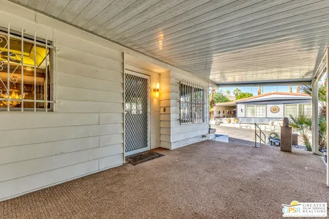 a view of a porch with furniture and floor to ceiling window