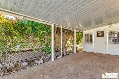 a patio with table and chairs and couches with wooden floor