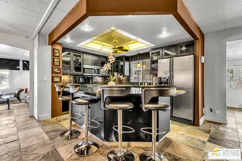 a kitchen with refrigerator and chairs