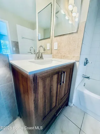 a bathroom with a sink a mirror and bathtub