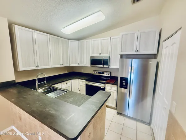 a kitchen with granite countertop a refrigerator and a sink