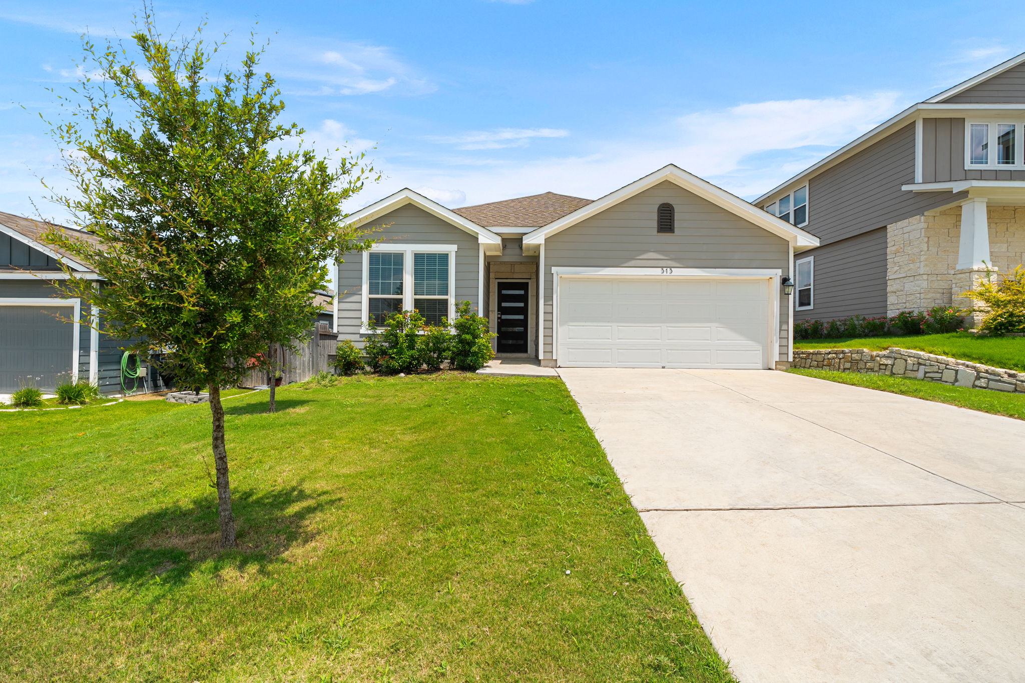 313 Mclintock Road Jarrell, TX 76537 - Photo 1 of 40 A well-maintained lawn welcomes visitors to this charming single-story residence with an integrated garage and concrete driveway.