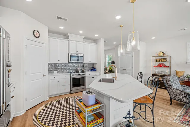 a kitchen with a appliances dining table and chairs
