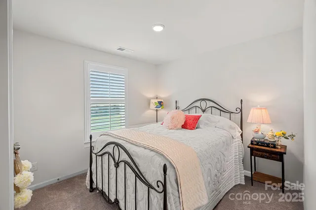 a bedroom with a bed and a lamp on the dresser