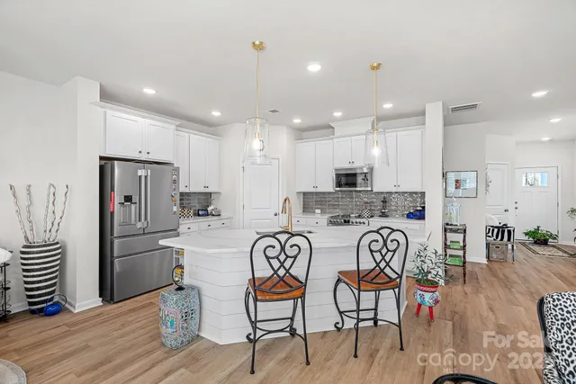 a kitchen with stainless steel appliances granite countertop a refrigerator and a stove top oven