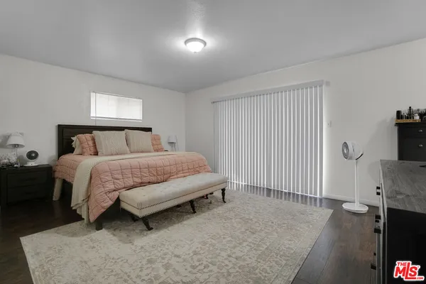 a bedroom with a bed and a flat tv screen on the dresser