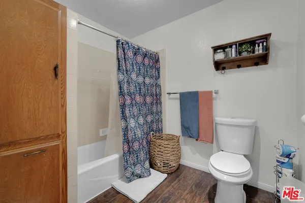 a bedroom with furniture a flat screen tv and a window