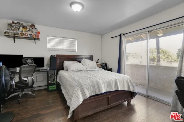 a bedroom with furniture a bed and a flat tv screen