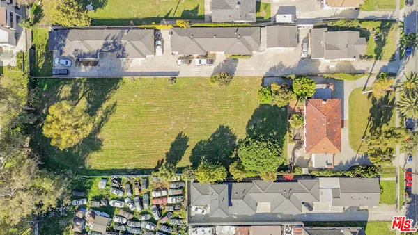 an aerial view of residential houses with outdoor space and swimming pool