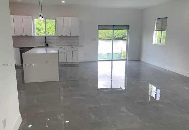 a kitchen with stainless steel appliances granite countertop a stove a sink a refrigerator and a cabinets