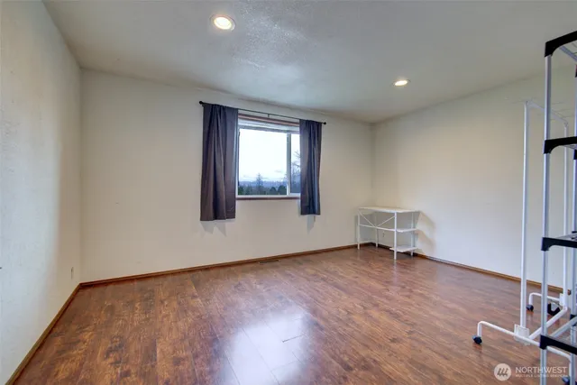 an empty room with wooden floor and a window
