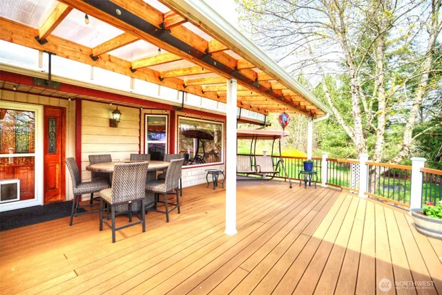 a view of a patio with dining table and chairs with wooden floor and fence