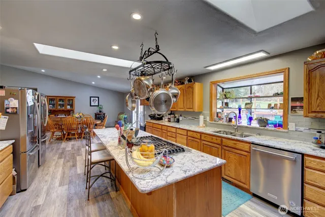 a kitchen with a table chairs stove and wooden floor